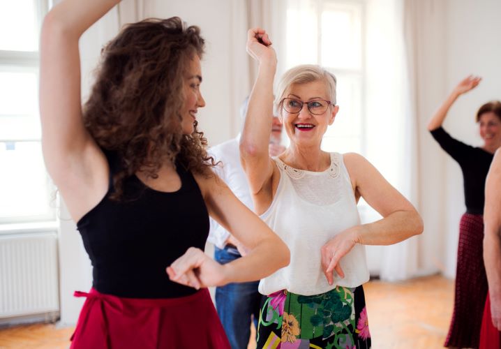 Older woman discovering her passion for dancing taking hip hop class with dance instructor