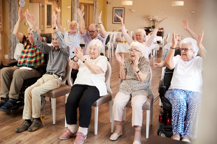 Senior citizens taking exercise and fitness class in retirement home